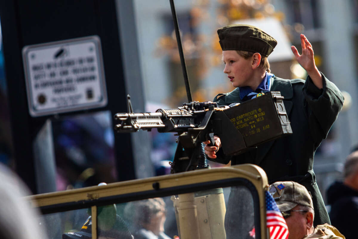 A child waves from the back of a jeep with an M60 during a Veterans Day parade in Reno, Nevada, on November 11, 2022. Ty O'Neil / SOPA Images / LightRocket via Getty Images
