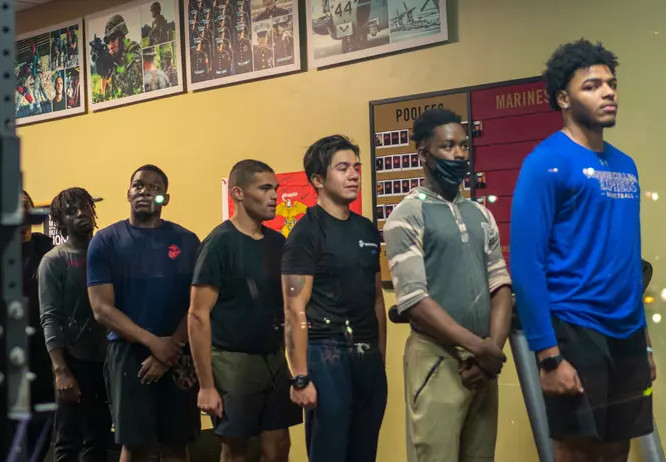 Men who have signed up to join the U.S. Marines stand in line to do qualifying pull-ups at recruiting station November 16, 2021 in New York City. (Photo: Robert Nickelsberg
